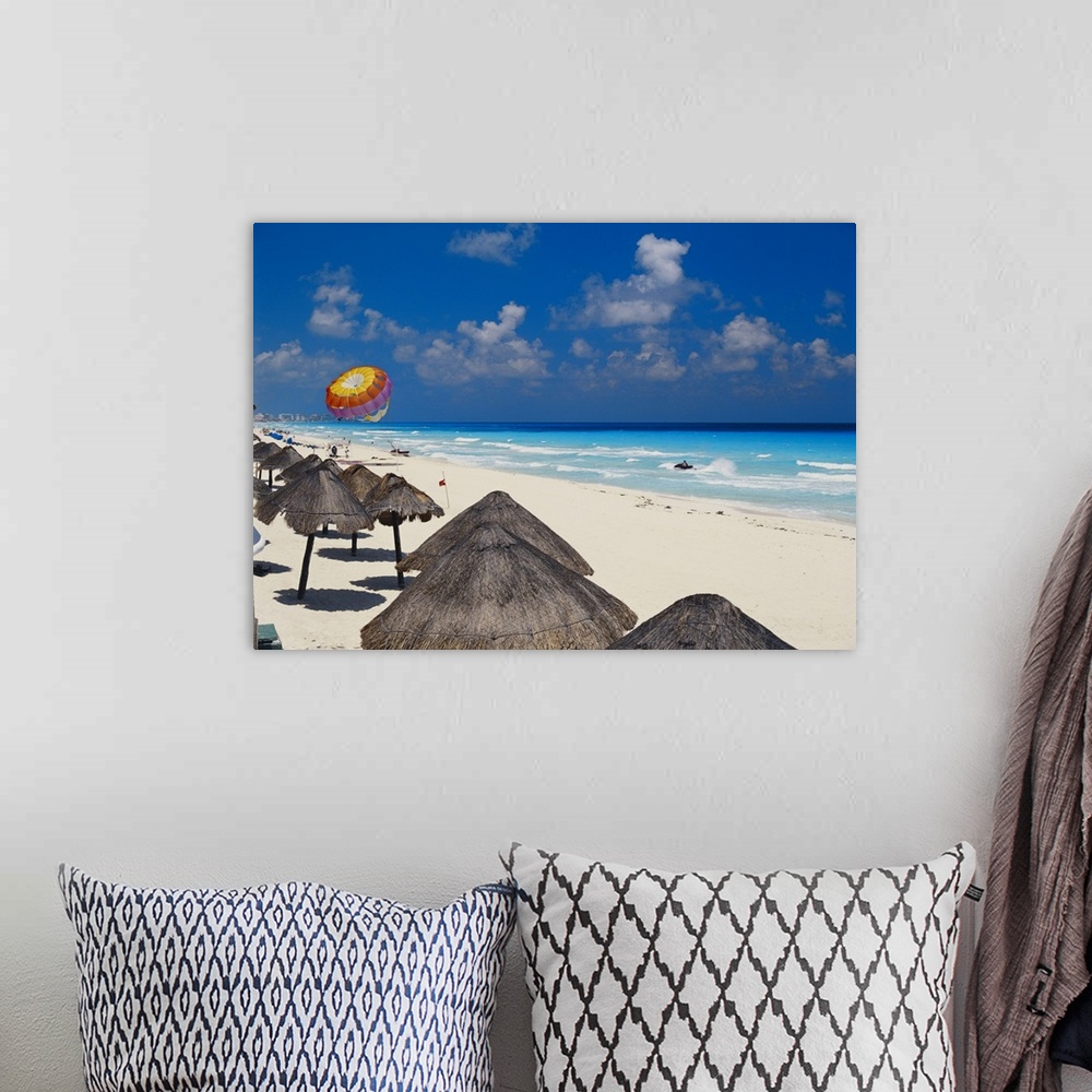 A bohemian room featuring Mexico, Cancun, sunshades along beach with parachute in background