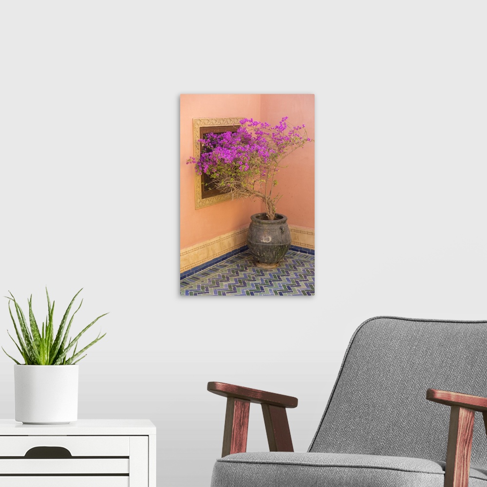 A modern room featuring Morocco, Marrakech. Bougainvillea labra in purple pot next to ochre colored walls on tiled floor.