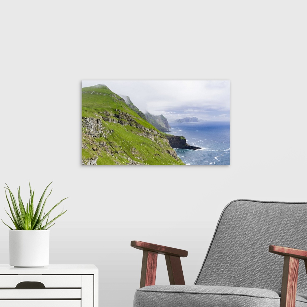 A modern room featuring The island Mykines,in the background the island Vagar, part of the Faroe Islands in the North Atl...