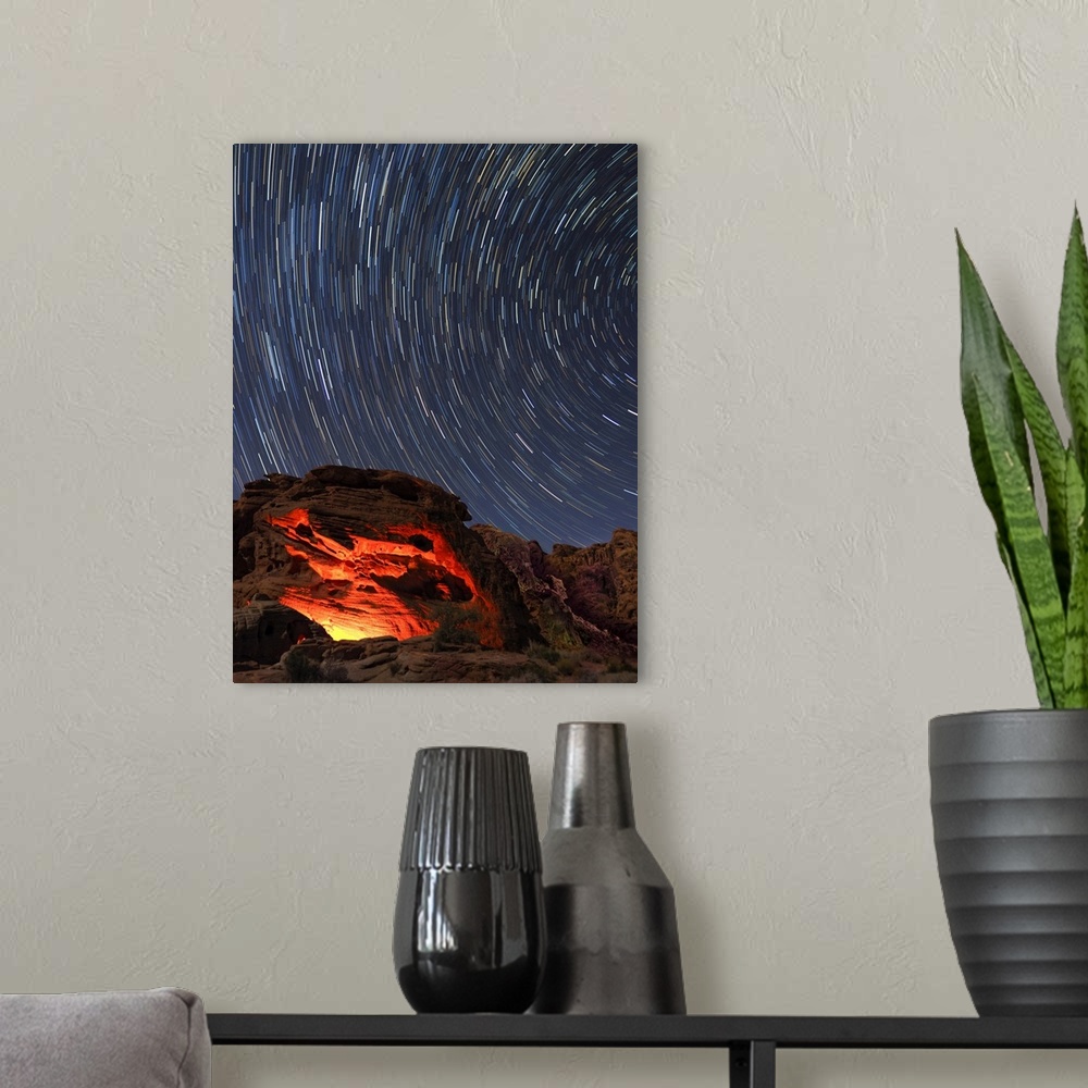 A modern room featuring Usa, Nevada. Valley of Fire State Park, star trails and campfire glowing in sandstone rocks.