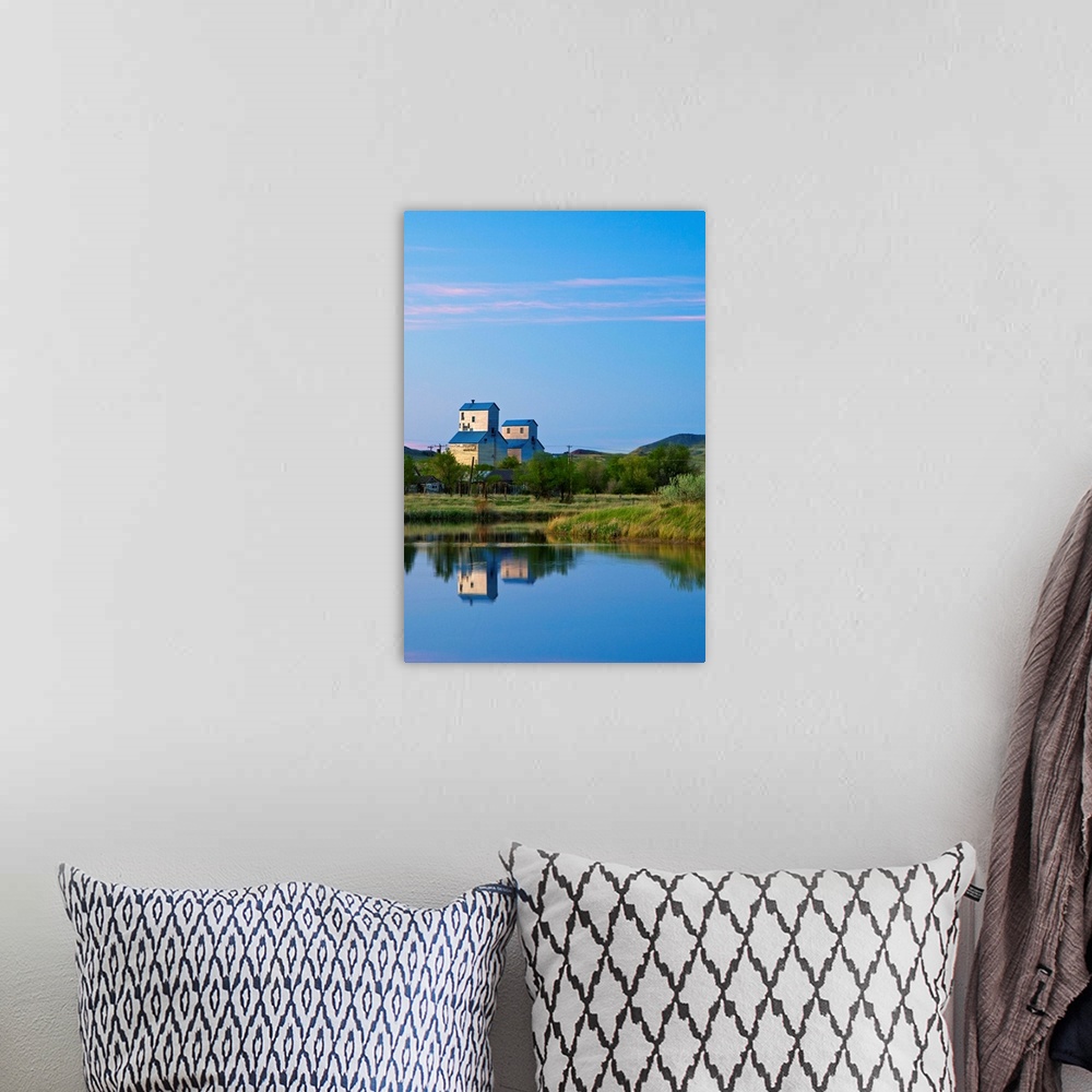 A bohemian room featuring Pair of grain elevators reflect into pond at Sentinel Butte North Dakota