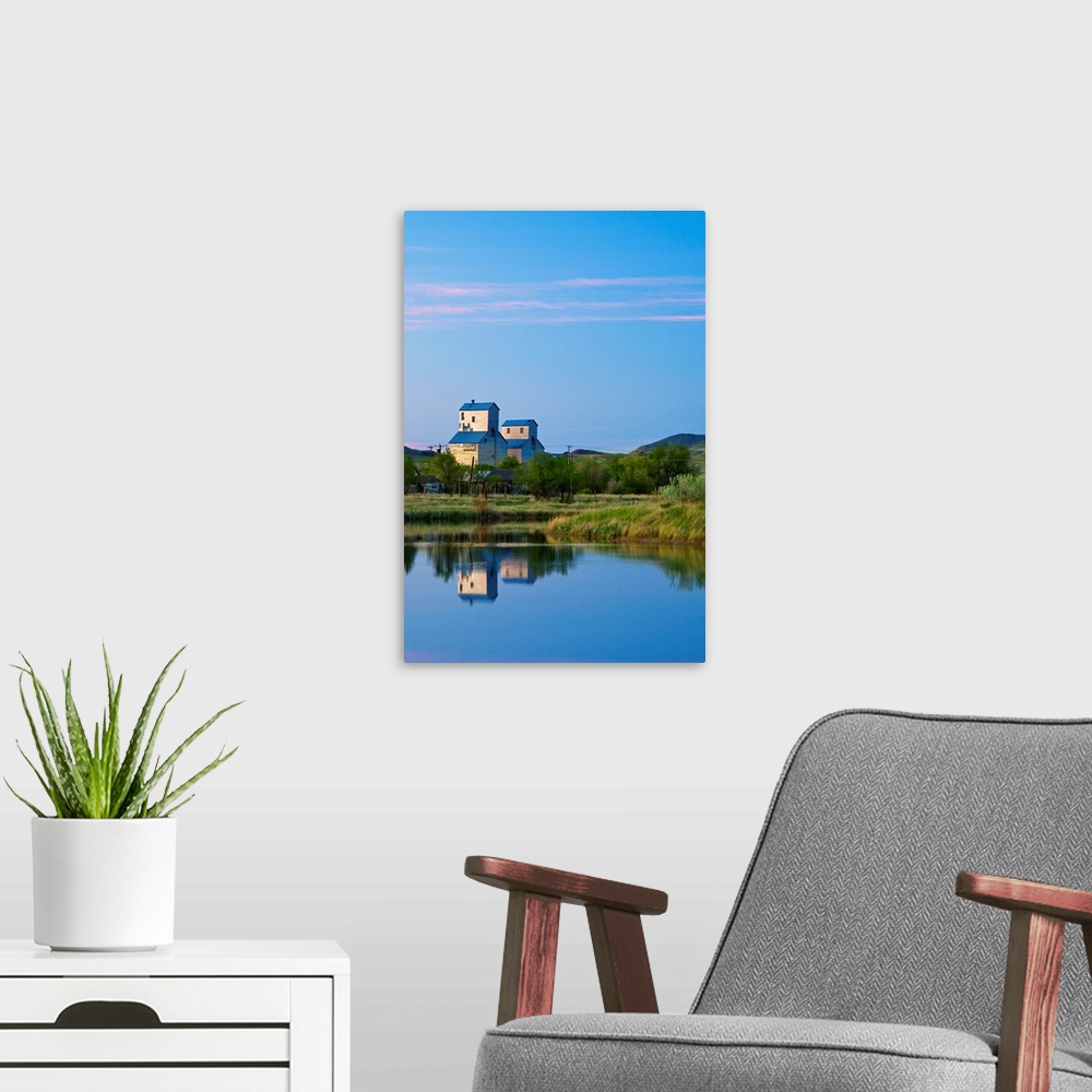 A modern room featuring Pair of grain elevators reflect into pond at Sentinel Butte North Dakota