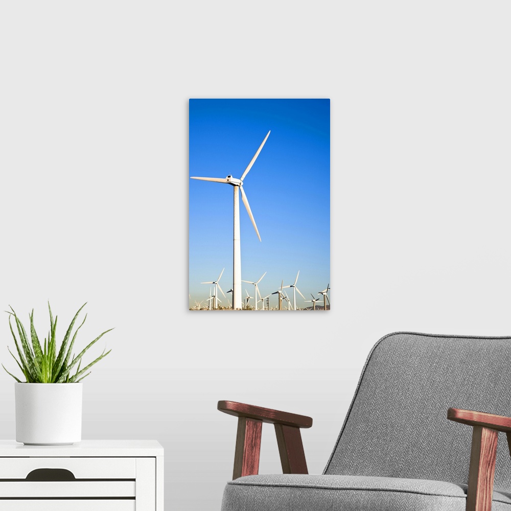 A modern room featuring Palm Springs, California. View of wind turbines in the desert under a clear blue sky.