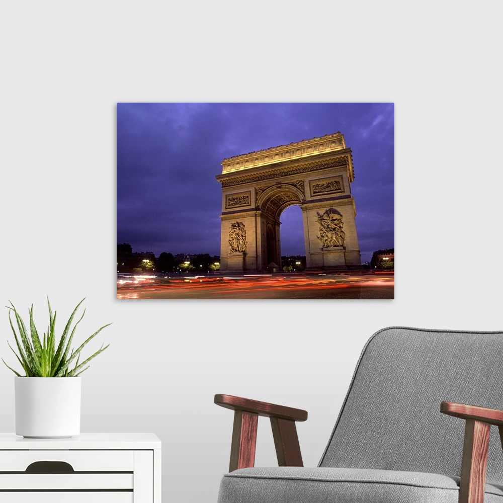 A modern room featuring Paris, France. Famous Arc de Triomphe Monument at Sunset.