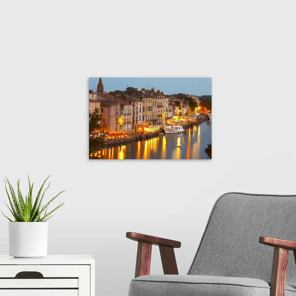 A modern room featuring Restaurants along the l'Herault river. L'Herault river. A fishing boat. Agde town. Languedoc. Fra...