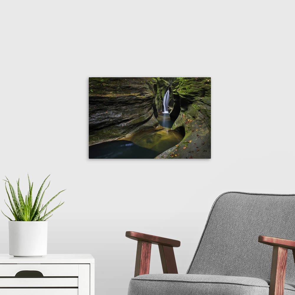 A modern room featuring Robinson falls, also known as corkscrew falls, carves through a small gorge of black hand sandsto...
