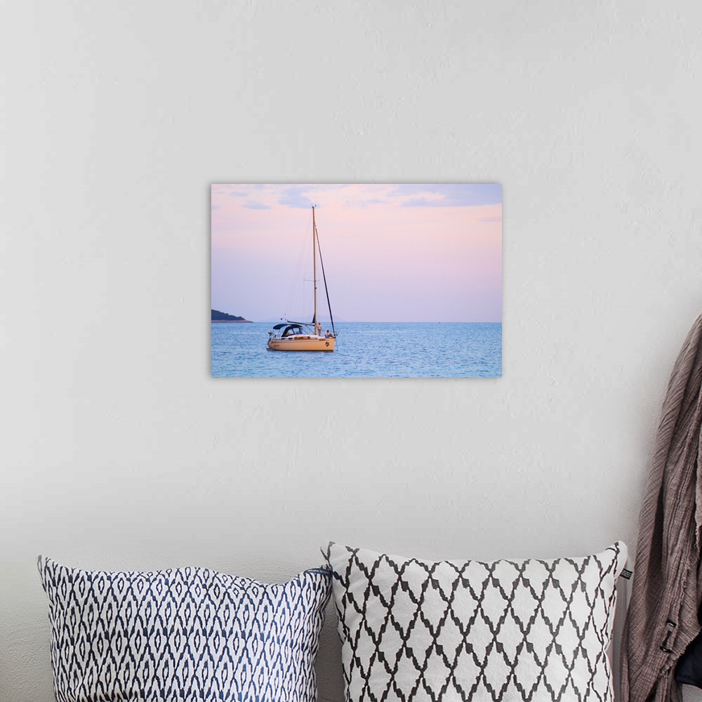 A bohemian room featuring A sailing boat moored in the bay with two people on the deck off Korcula at sunset. Prizba villag...