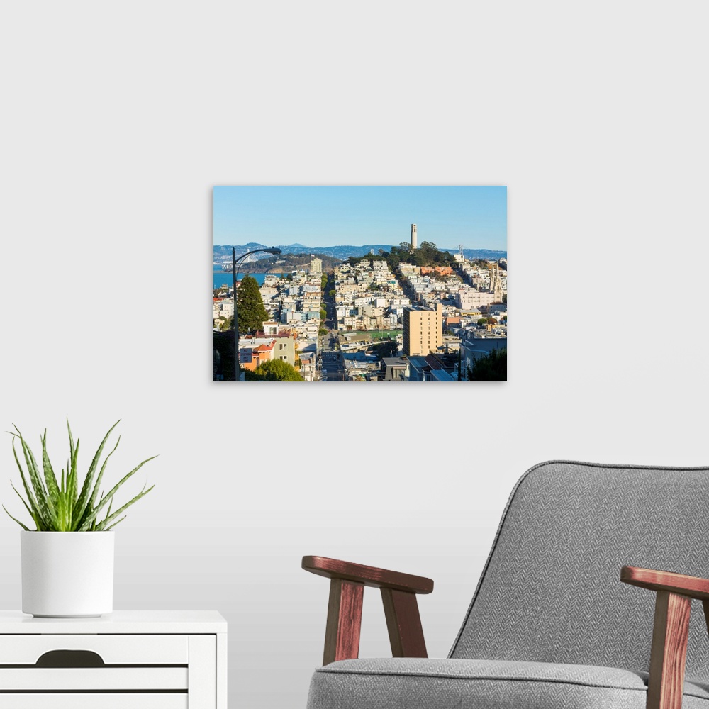 A modern room featuring San Francisco California hills of the city and Coit Tower in sunshine with streets and bridges in...