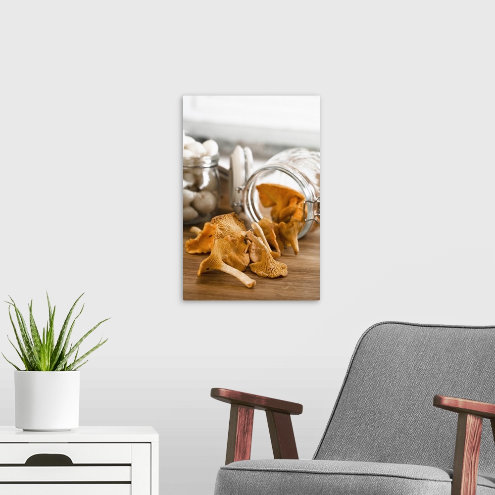 A modern room featuring Stockholm, Sweden - Closeup of dried mushrooms coming from a jar that's lying on a countertop. Ve...