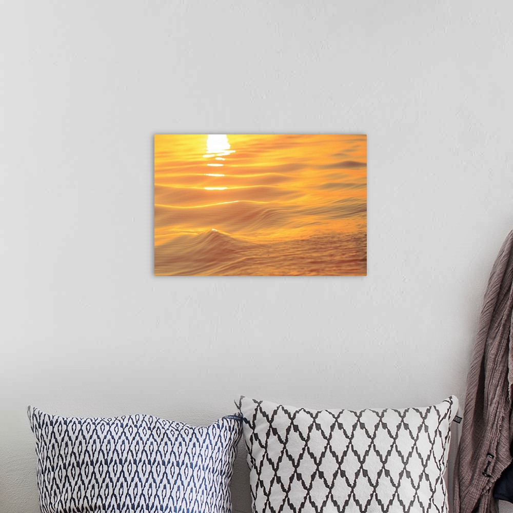 A bohemian room featuring Sunset colors and patterns on small waves in water.