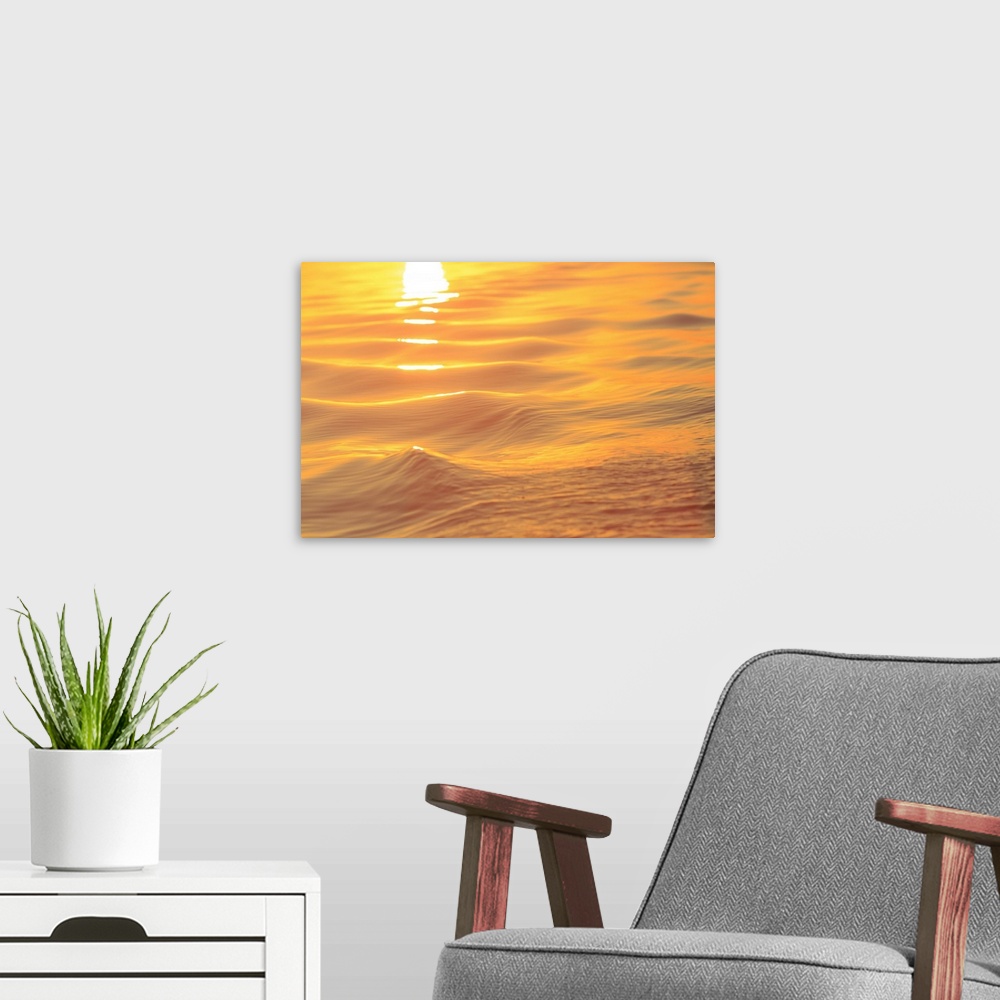 A modern room featuring Sunset colors and patterns on small waves in water.