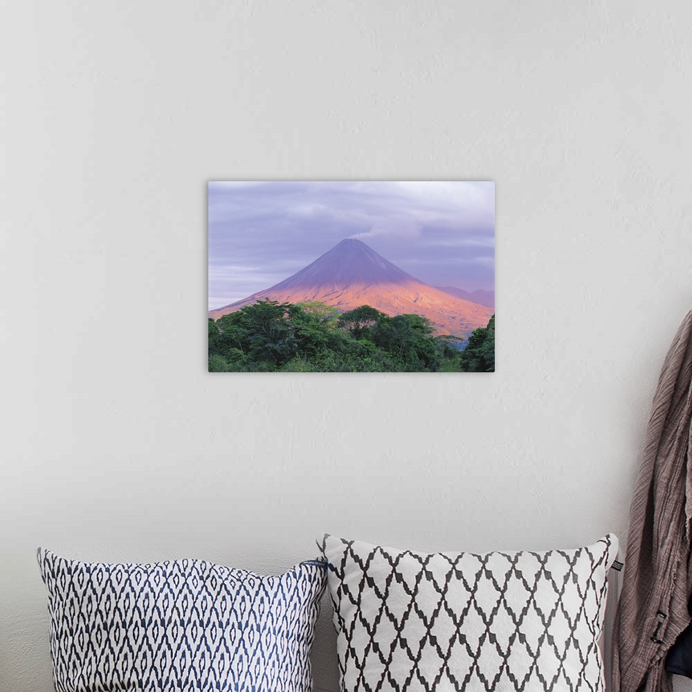 A bohemian room featuring Sunset light peers through the clouds to illuminate the flanks of Arenal Volcano (1,670m/5,479ft)...