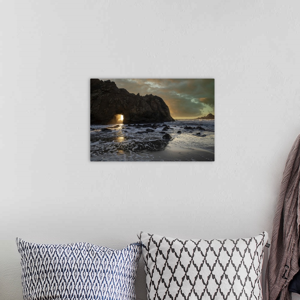 A bohemian room featuring Sunset Shines Through A Tunnel In This Sea Rock At Big Sur