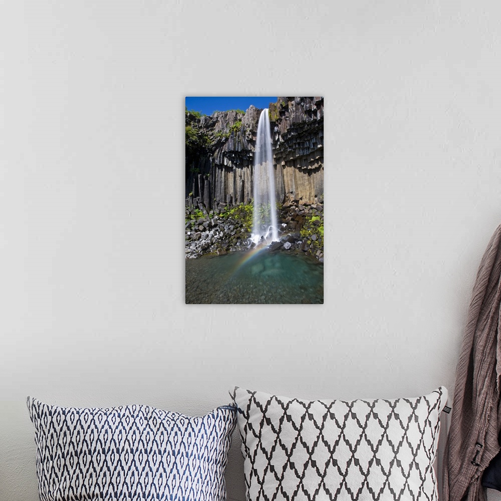 A bohemian room featuring Svartifoss, a waterfall in southern Iceland, cascades over ancient basaltic columns.