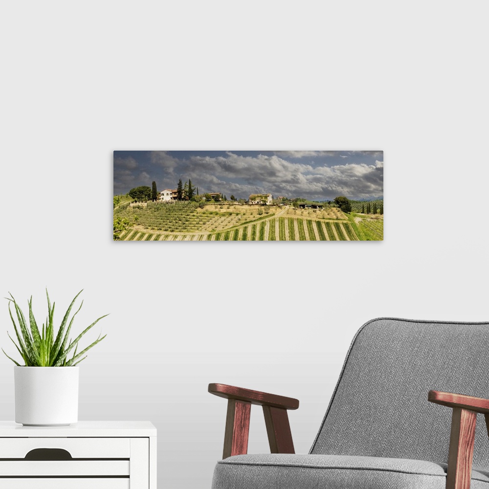 A modern room featuring Tuscan landscape under thunder clouds. Farmhouse with vineyard. Tuscany, Italy.
