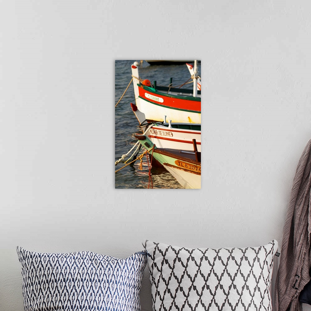 A bohemian room featuring Typical Provencal fishing boats painted in bright colours white, blue, green red yellow, moored a...