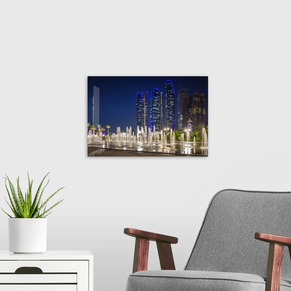 A modern room featuring UAE, Abu Dhabi, Emirates Palace Hotel fountains and Etihad Towers, dusk