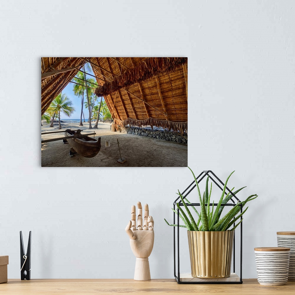 A bohemian room featuring USA, Hawaii, Big Island. Canoe on display inside the Halau thatched A-frame structure at the Nati...