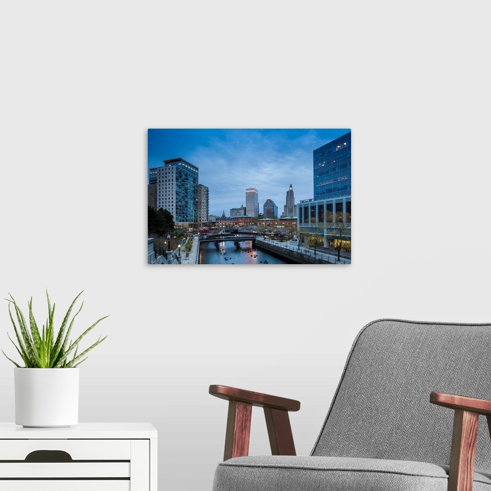 A modern room featuring USA, Rhode Island, Providence, city skyline from Waterplace Park at dusk