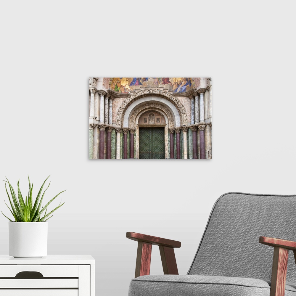 A modern room featuring Venice, Veneto, Italy - Carvings and columns line the entrance to an arched church door. Horizont...