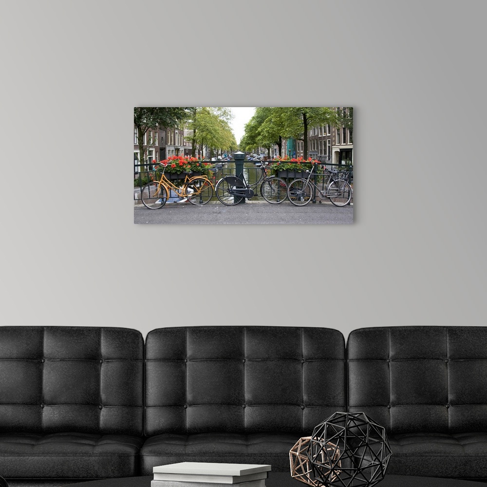 A modern room featuring View from a bridge over a canal in Amsterdam with colorful bikes and red flowers