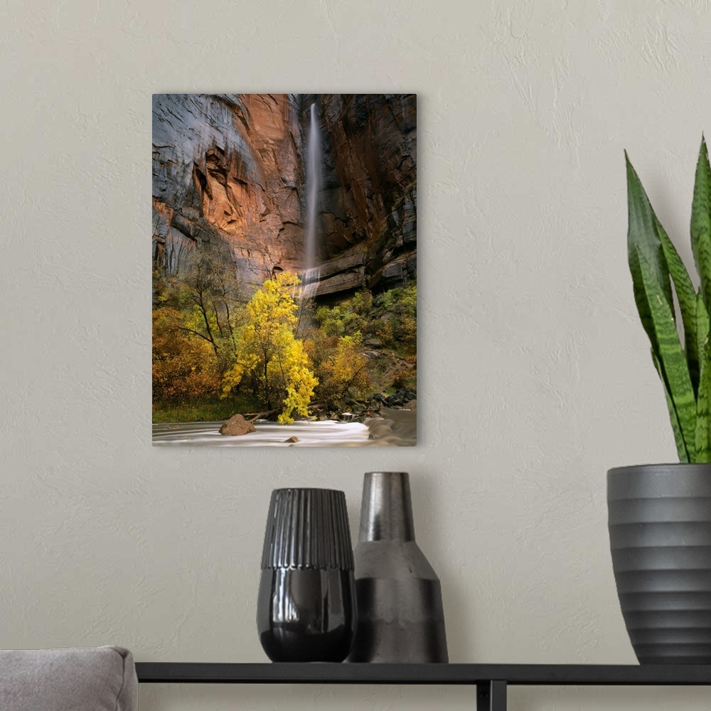 A modern room featuring Zion National Park, Utah. Ephemeral waterfall pours over cliff above Virgin River during autumn r...
