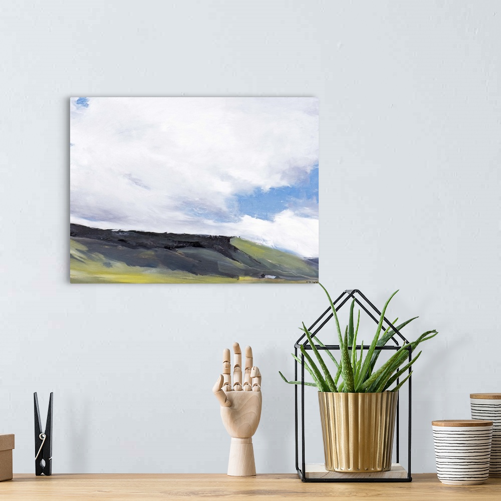 A bohemian room featuring Contemporary painting of a hillside landscape under a sky with large clouds hanging overhead.