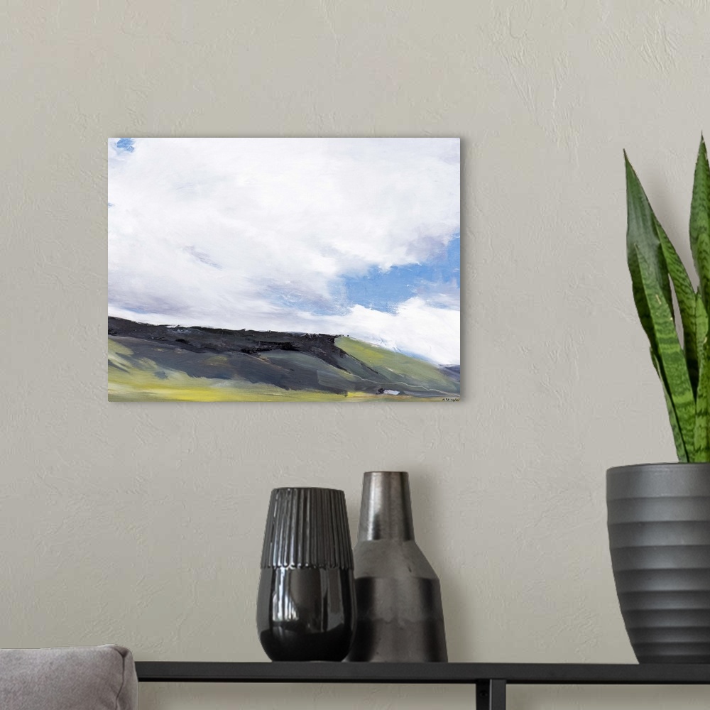 A modern room featuring Contemporary painting of a hillside landscape under a sky with large clouds hanging overhead.