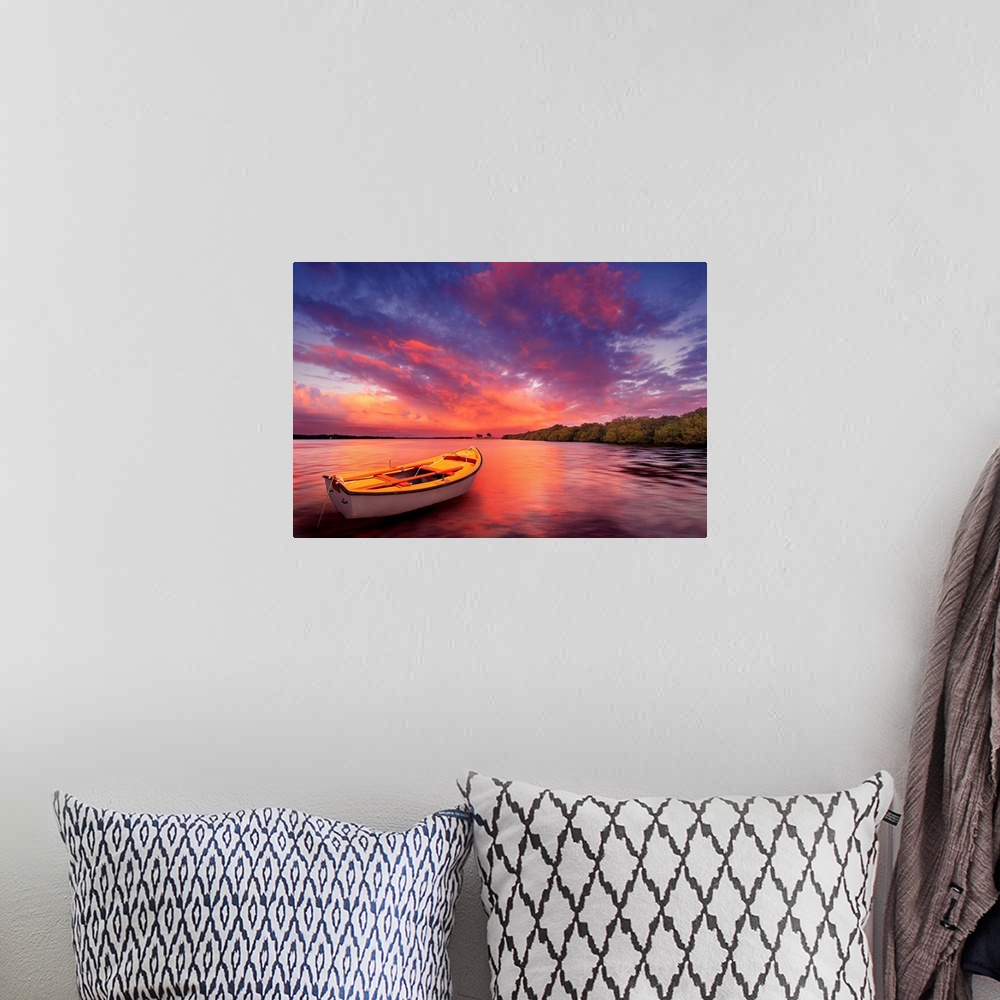 A bohemian room featuring A rowboat watches an amazing sunset.