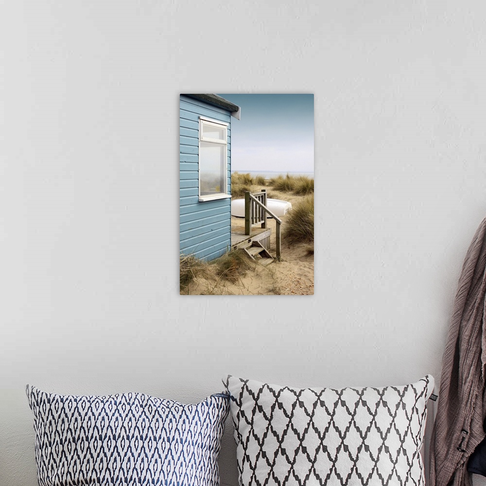 A bohemian room featuring View of the side of a blue wooden beach hut with a wooden terrace, looking towards the coast/beac...