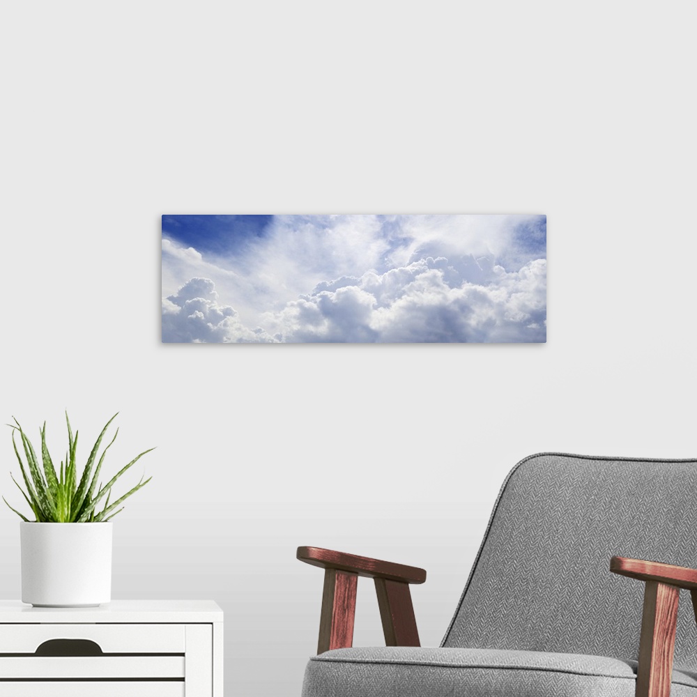 A modern room featuring Panoramic shot of a blue sky with lots of fluffy clouds.