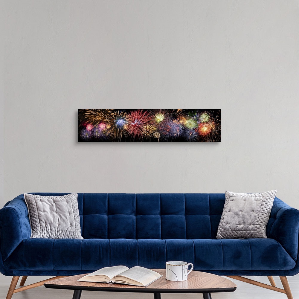 A modern room featuring Colorful panoramic view of fireworks over night sky.