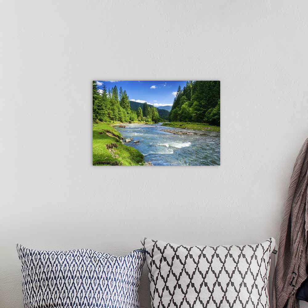 A bohemian room featuring Landscape with mountains trees and a river in front.
