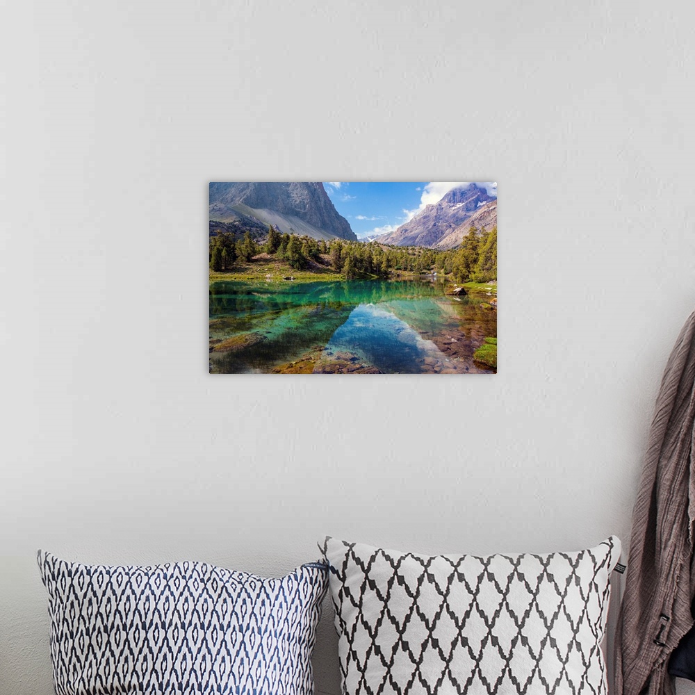 A bohemian room featuring Scenic landscape with vibrant water surface forest and high mountain peak blue sky.