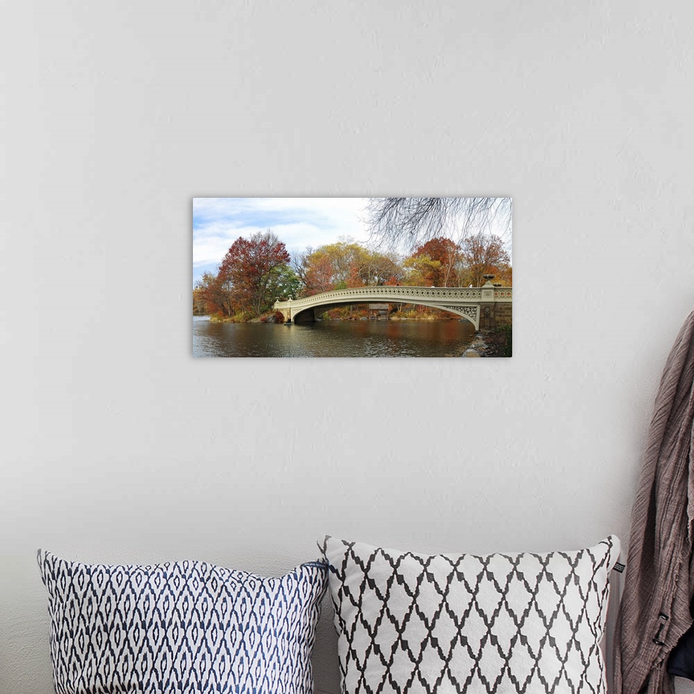 A bohemian room featuring Central Park panorama in autumn with skyscrapers, foliage, lake and Bow Bridge.