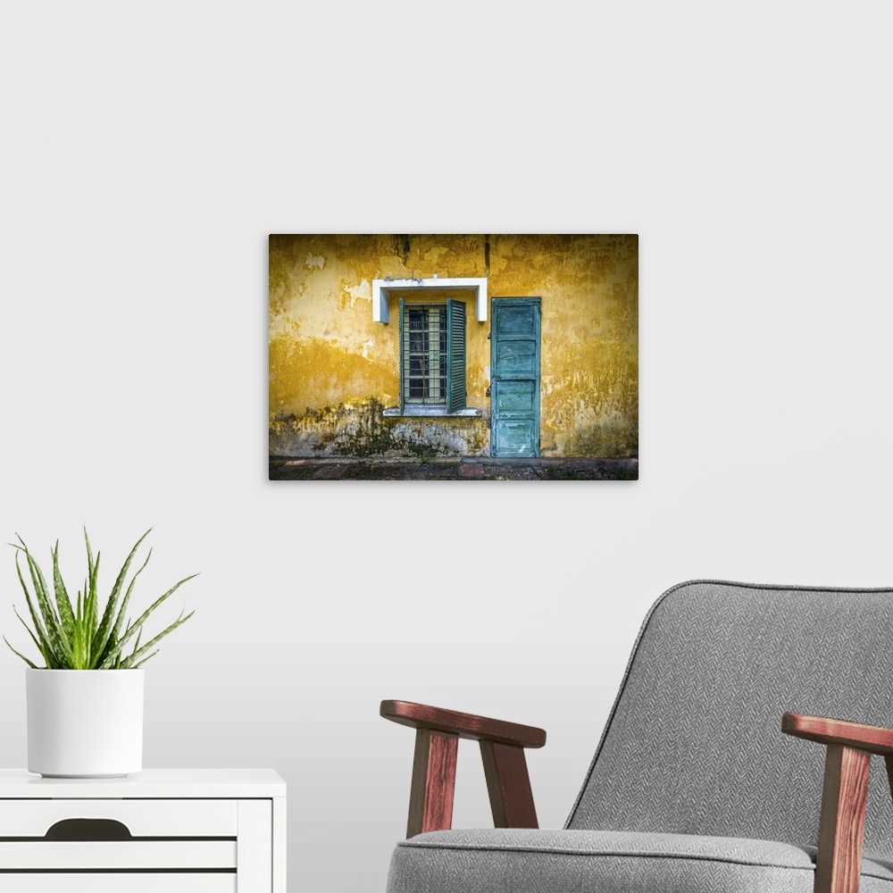 A modern room featuring Outside view of deserted house with details in Vietnam. Old and grungy yellow wall with window an...