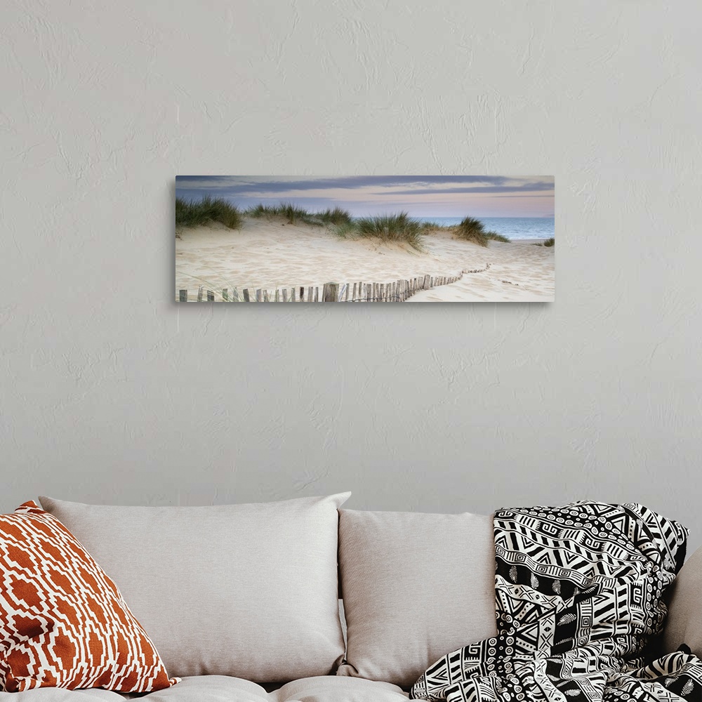 A bohemian room featuring Panorama landscape of sand dunes on beach at sunrise.