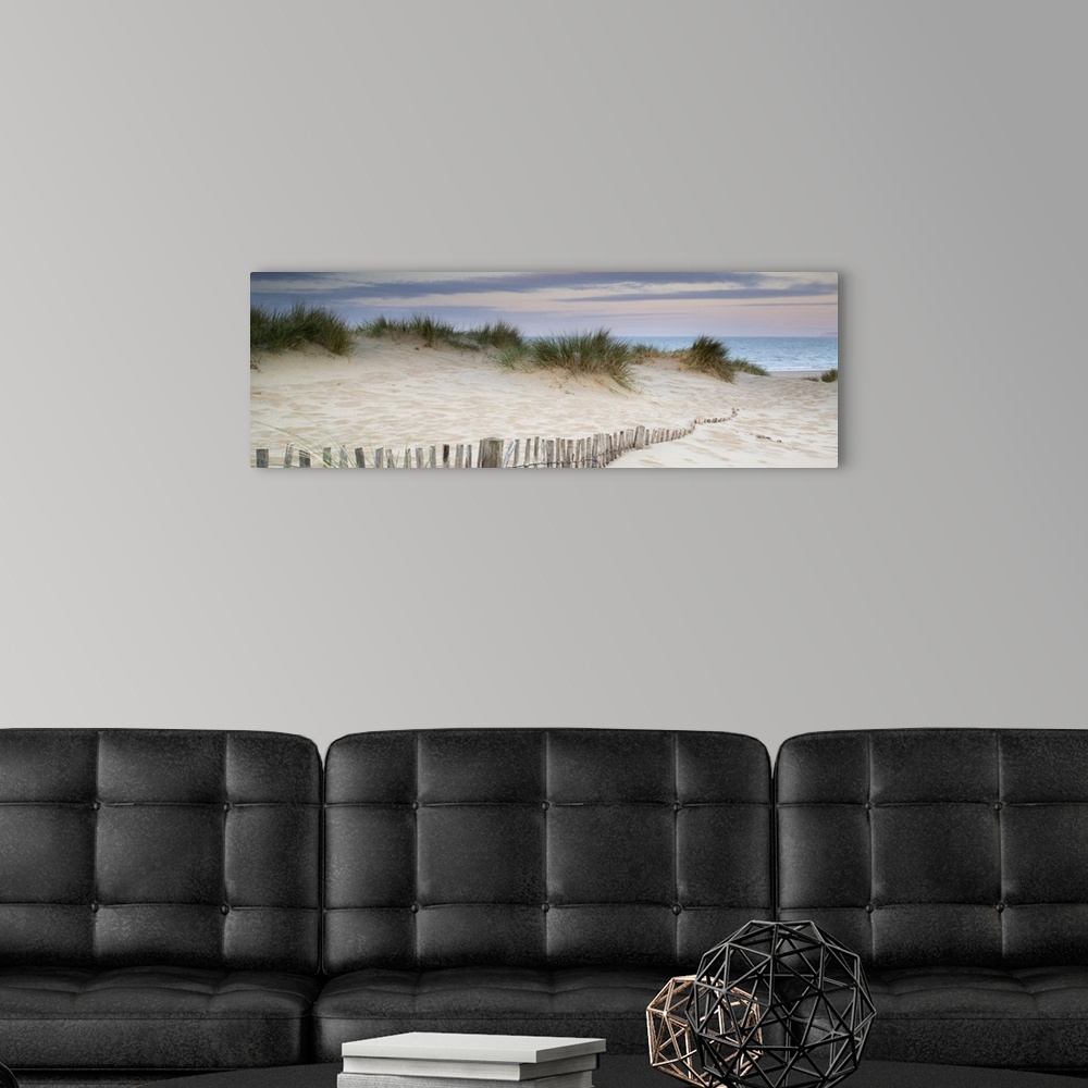 A modern room featuring Panorama landscape of sand dunes on beach at sunrise.