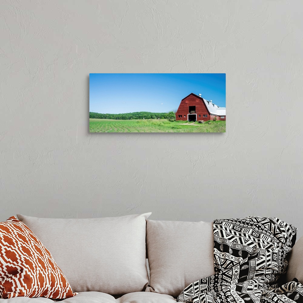 A bohemian room featuring A red barn, green fields, and blue sky of a classic Vermont family farm.