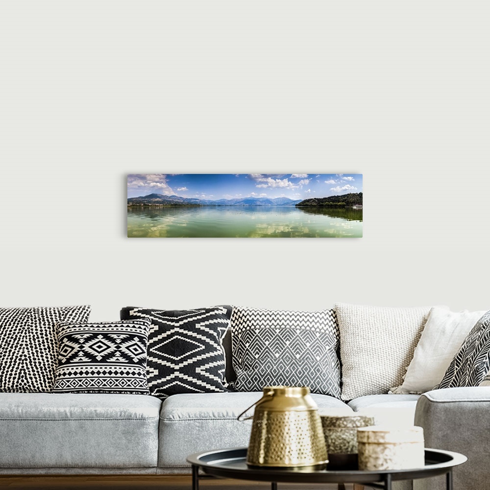 A bohemian room featuring Panoramic view of Kastoria lake under blue sky, Greece.