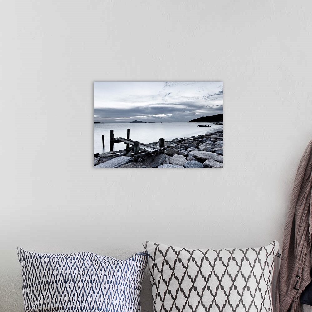 A bohemian room featuring Black and white photography of sky and sea at sunset.