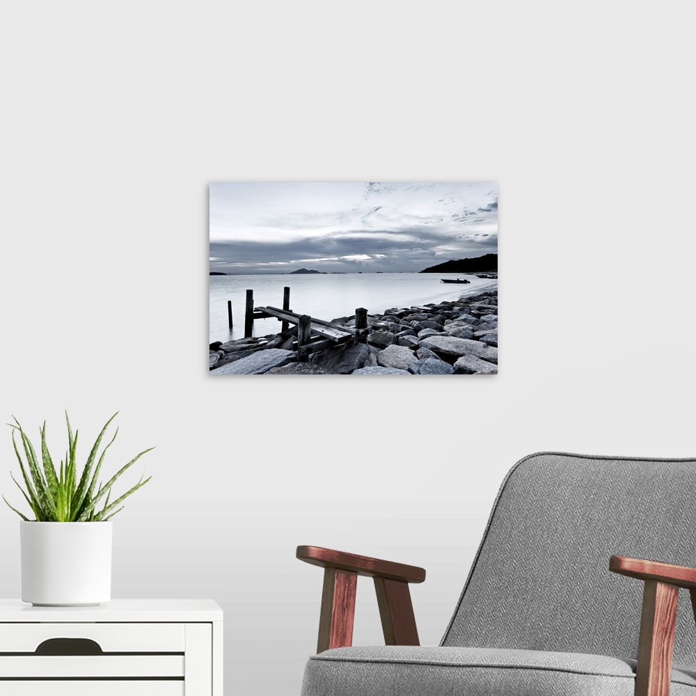 A modern room featuring Black and white photography of sky and sea at sunset.