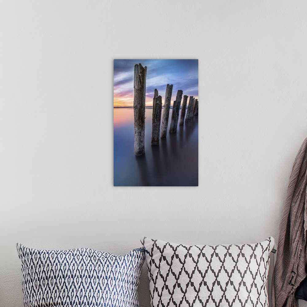A bohemian room featuring Unusual pillars in the water on the background of colorful sky with bright clouds.