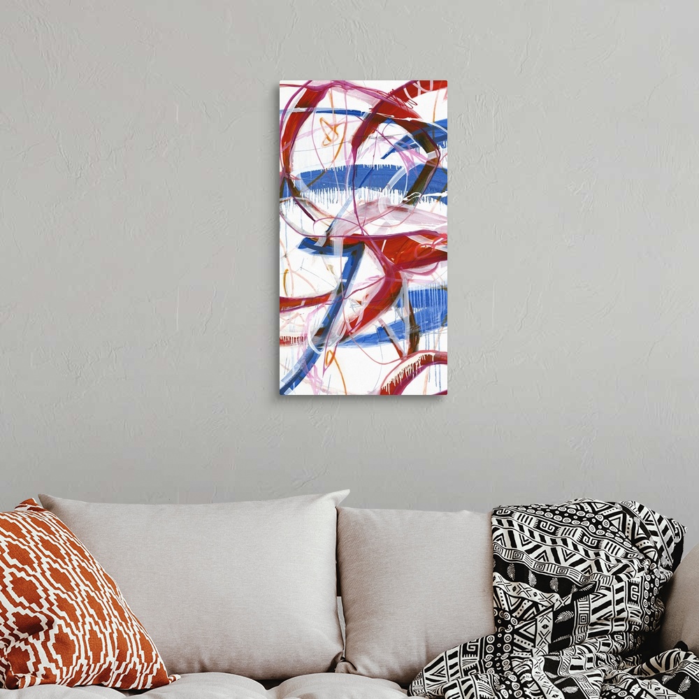 A bohemian room featuring Large abstract painting with red, blue, pink, orange, black, and white lines varying in size and ...