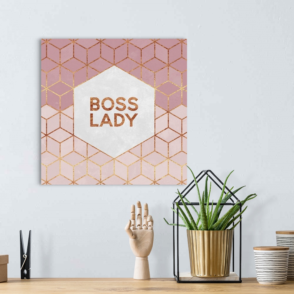 A bohemian room featuring The words 'Boss Lady' in gold letters, centered on a white hexagon surrounded by rose pink diamon...