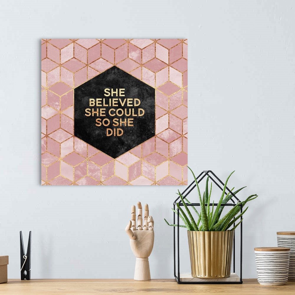 A bohemian room featuring The words 'She Believed She Could so She Did' in gold letters, centered on a black hexagon surrou...