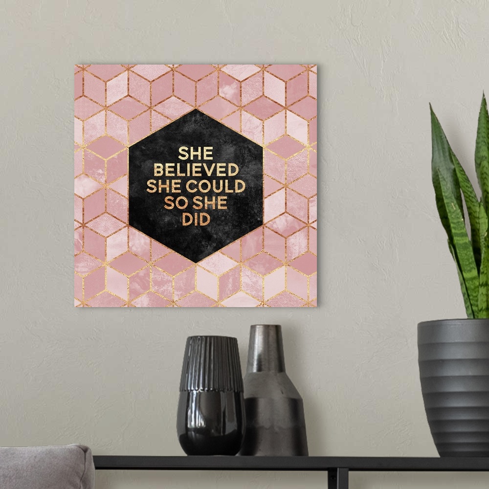 A modern room featuring The words 'She Believed She Could so She Did' in gold letters, centered on a black hexagon surrou...