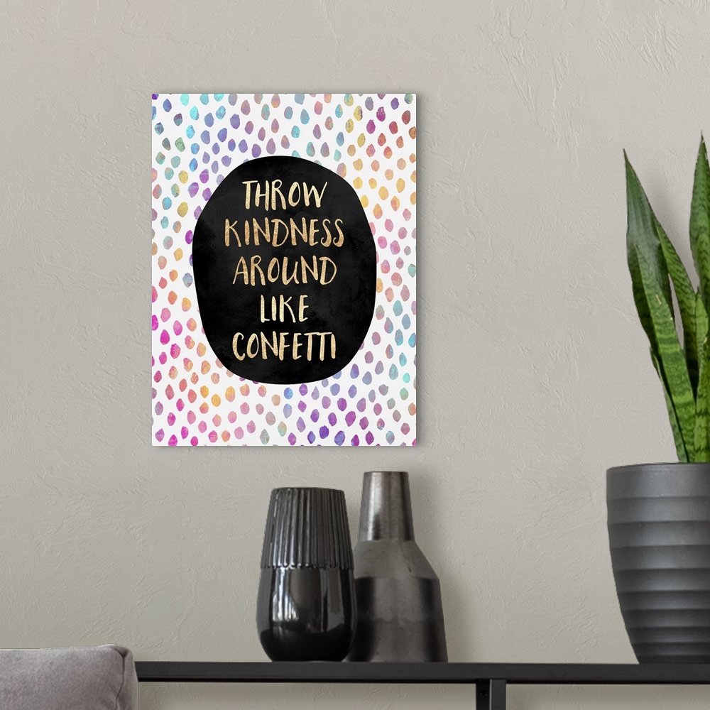 A modern room featuring The words 'throw kindness around like confetti' in gold letters on a black oval, surrounded by ra...