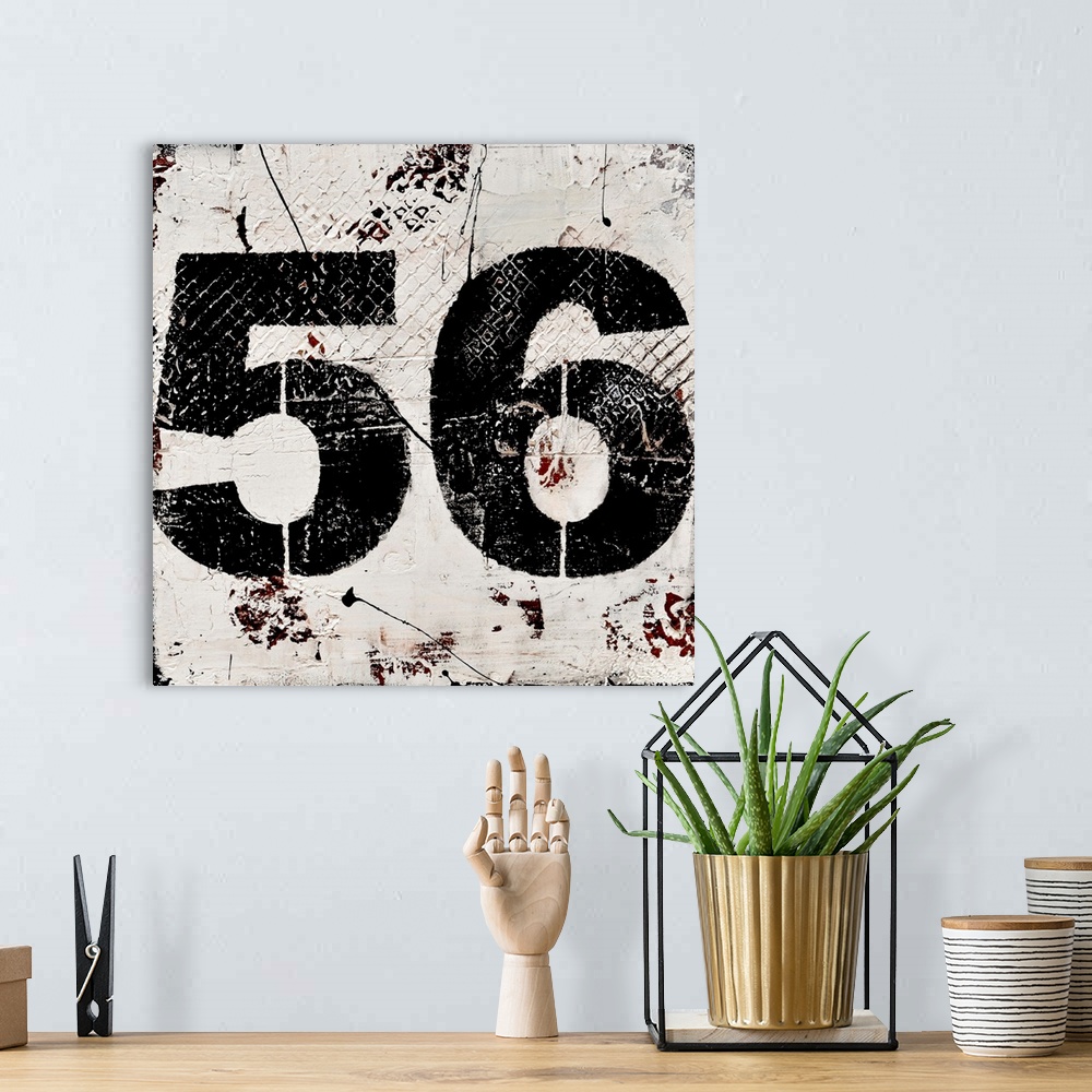 A bohemian room featuring A contemporary abstract painting using a neutral toned background with a bold black number fifty-...
