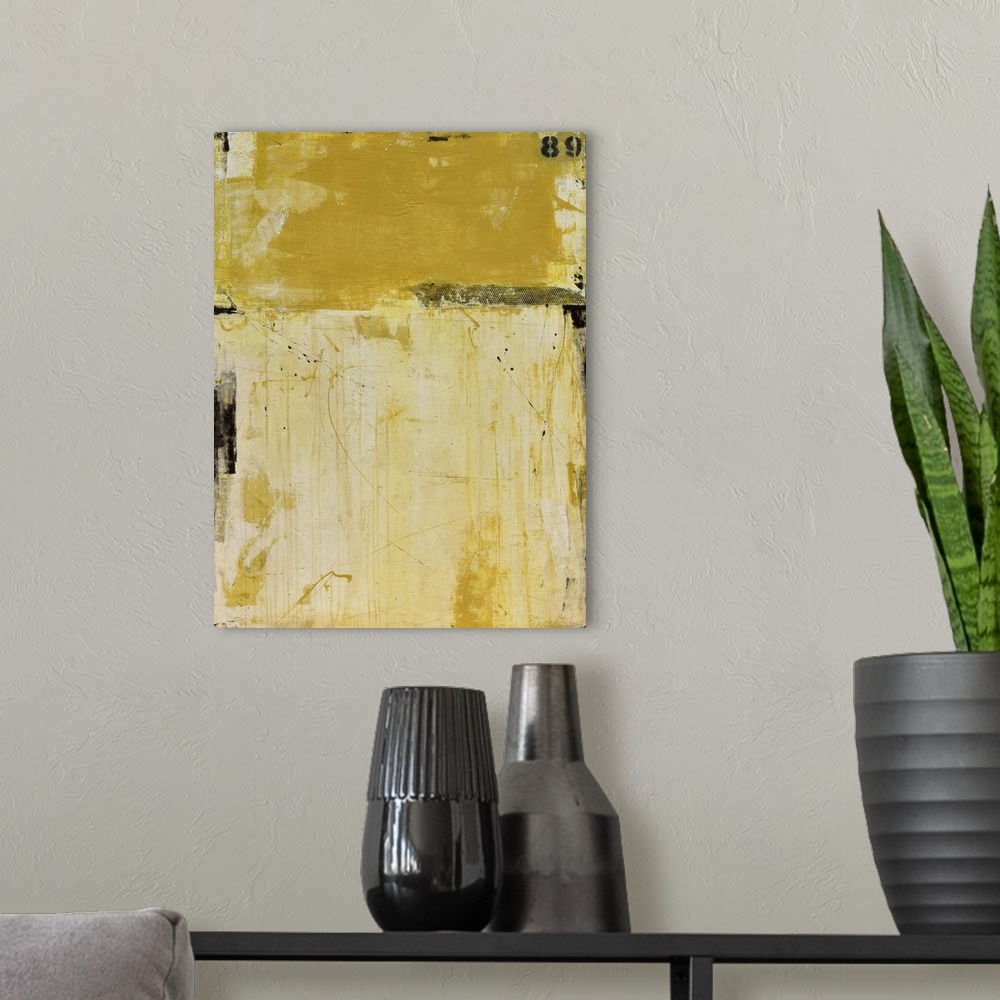 A modern room featuring A contemporary abstract painting using two tones of yellow meeting face to face.